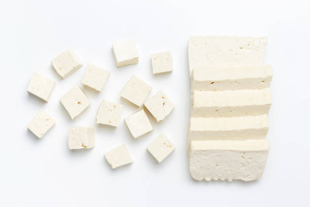 A sliced pieces and cubes of tofu on white background close-up. stock photo