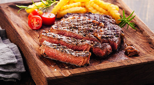 Sliced Steak Ribeye with french fries Sliced Steak Ribeye with french fries on serving board block on wooden background cut of meat stock pictures, royalty-free photos & images