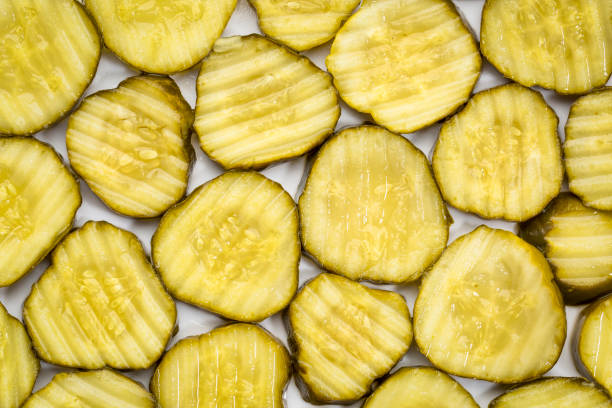 slices of cucumber pickles slices of cucumber pickles - background on a white plate pickle stock pictures, royalty-free photos & images