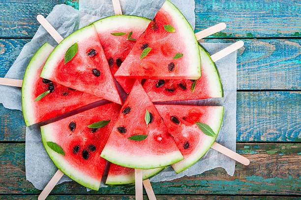 slices of fresh juicy watermelon on a paper closeup - watermeloen stockfoto's en -beelden