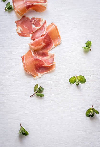 Slices of jamon on the white background Slices of jamon on the white background delicatessen photos stock pictures, royalty-free photos & images