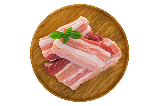 Slices of raw fresh pork belly cut on wooden plate stock photo