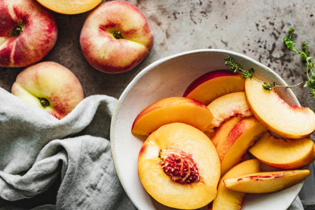 Slices of ripe peaches in a bowl. stock photo