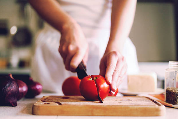 cortar tomates vermelhos frescos, - woman chopping vegetables imagens e fotografias de stock