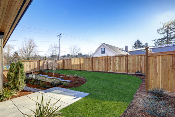 Sloped backyard of New construction home with open floor plan Sloped backyard surrounded by wooden fence. Exterior of New Luxury  home with tiled walkway and green lawn. Northwest, USA fence stock pictures, royalty-free photos & images