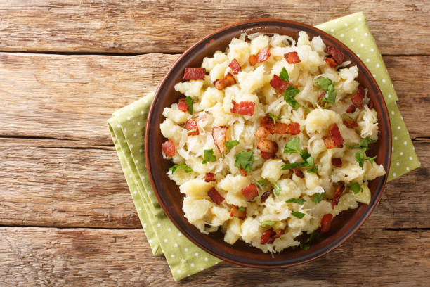 Slovak Halusky Grated Potato Dumplings with sauerkraut and bacon closeup in the plate. horizontal top view stock photo