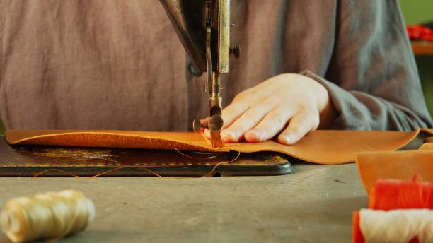 Slow motion is the process of making and sewing a leather bag. Close-up of a stitch on a sewing machine Slow motion is the process of making and sewing a leather bag. Close-up of a stitch on a sewing machine. High quality 4k footage garment factory stock pictures, royalty-free photos & images