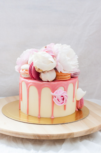 small-birthday-cake-with-melted-pink-chocolate-fresh-peonies-and-on-picture-id1252734083