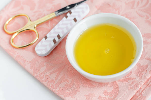 Small bowl with olive oil for natural nails and cuticle treatment. Manicure and pedicure concept. Small bowl with olive oil for natural nails and cuticle treatment. Manicure and pedicure concept. toenail stock pictures, royalty-free photos & images