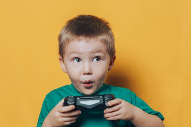 bambino con joystick su sfondo giallo - joystick soccer foto e immagini stock