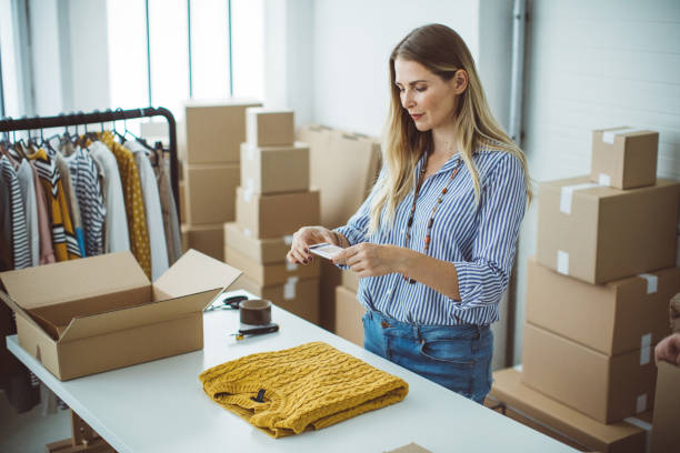 Small business owener Women, owener of small business packing product in boxes, preparing it for delivery. clothing photos stock pictures, royalty-free photos & images