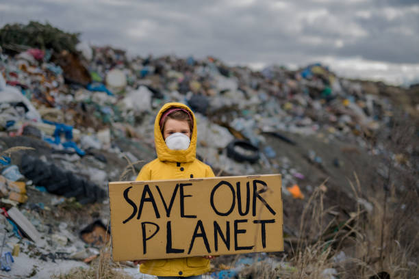 bambino piccolo che tiene un cartello sulla discarica, concetto di inquinamento ambientale. - cambiamento climatico foto e immagini stock