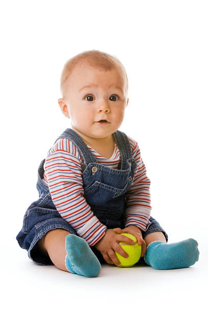 Small child in jeans holding tennis ball stock photo