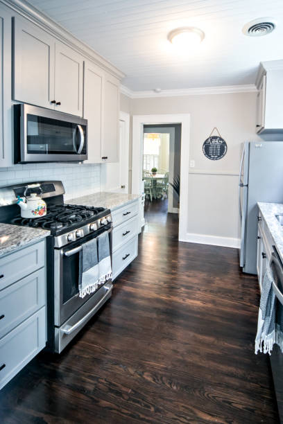 A small cottage kitchen with gray cabinets and dark hardwood floors in a short-term rental house stock photo