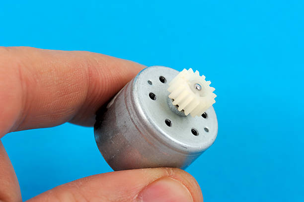 Small Electric Motor Thumbs holding a small DC electric motor. small gear motor stock pictures, royalty-free photos & images