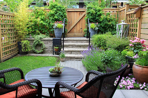 Small garden. Small townhouse garden with patio furniture amidst blooming lavender. ornamental garden stock pictures, royalty-free photos & images