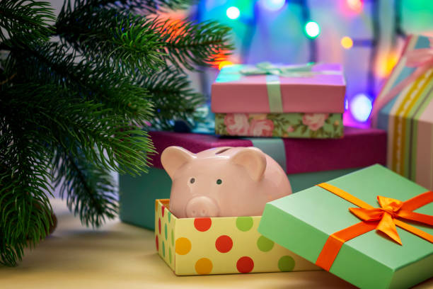 A small pink piggy bank in a festive box. Symbol of the New Year under the Christmas tree. Unusual gift. stock photo