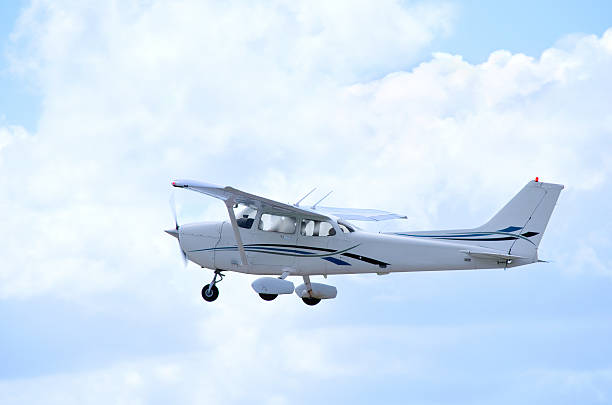 Small private single engine airplane in flight with clouds stock photo