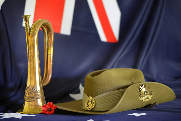A slouch hat in front of an Australian flag representing Anzac Day. Also a bugle and a poppy in the photo