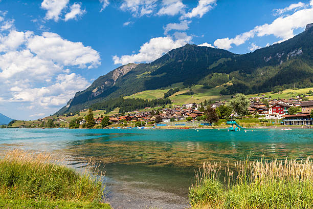 Small town Lungern in Swiss Alps Stunning view of the small town Lungern on the lake side of Lungernsee on Bernese Oberland of Switzerland. This town lies on the railway line between Lucerne and Interlaken. lungern village switzerland lake stock pictures, royalty-free photos & images