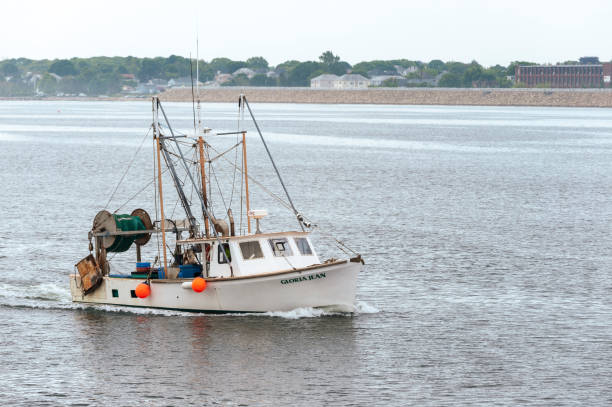 Small trawler Gloria Jean crossing New Bedford outer harbor stock photo