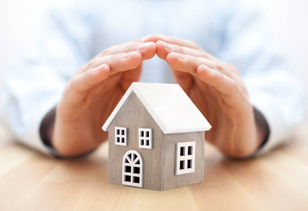 Small wooden house covered by hands stock photo