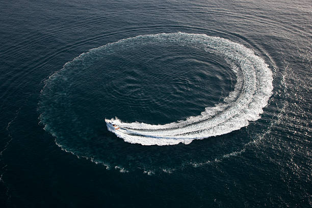 Small yacht making a circle in the water stock photo
