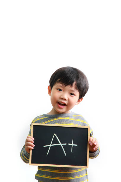 Smart boy holding chalkboard Smart little Asian boy holding a chalkboard with A+ sign, standing against a white background students exam results stock pictures, royalty-free photos & images