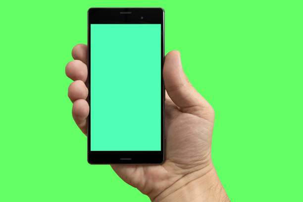 Smart phone in hand on isolated green screen Right hand holding a smart phone on chroma key background. smart phone green background stock pictures, royalty-free photos & images