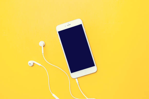 smart phone on yellow smart phone on yellow background with copy space headphones stock pictures, royalty-free photos & images