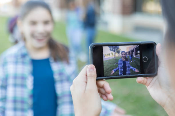 smart phone taking photo of teen girl outside high school - smartphone filming imagens e fotografias de stock