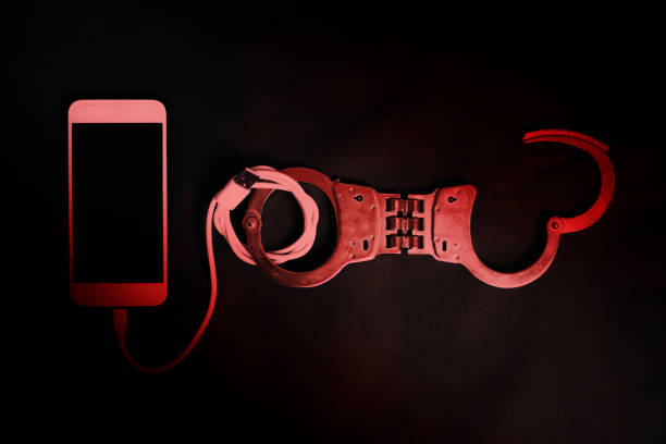 Smart phone with handcuff in the dark, Smart phone addiction concept stock photo