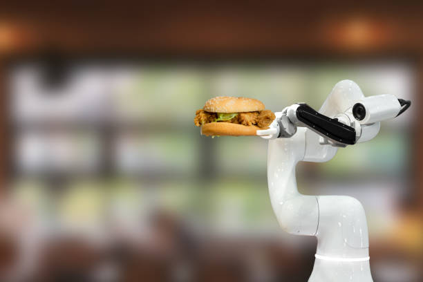 Smart robotic food holding a hamburger in a restaurant futuristic robot automation increase efficiency stock photo