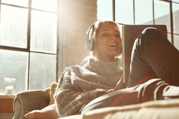 Smart technology's got her entertainment covered Shot of a happy young woman relaxing on the sofa and using headphones with a digital tablet free images for downloads stock pictures, royalty-free photos & images