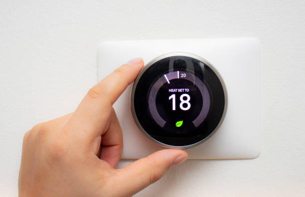 Smart Thermostat with a person saving energy with a soft shadow Smart Thermostat with a person saving energy with a soft shadow thermostat stock pictures, royalty-free photos & images