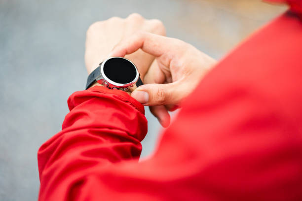 Smart trail runner man checking smart watch on rocky mountain. Athlete jog, exercising outdoor for healthy. Confident and powerful marathon man running workout and cardio. Sport and Lifestyle concept stock photo