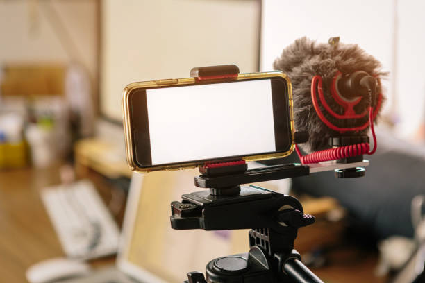 smartphones connected to an external microphone and coupled to a tripod. - smartphone filming imagens e fotografias de stock