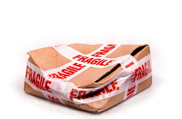 a smashed box with fragile tape all around it - bräcklighet bildbanksfoton och bilder