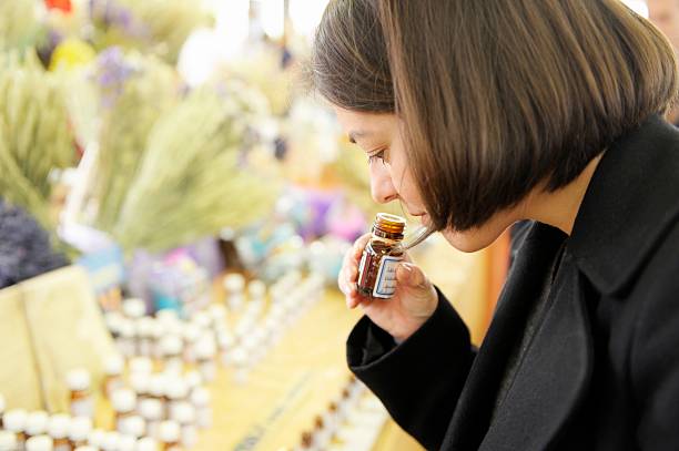 smelling essential oils on a market stall - essential oils smell stockfoto's en -beelden