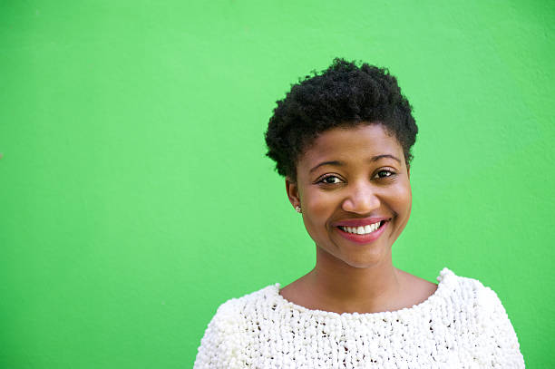 smiling african american woman on isolated green background - gekleurde achtergrond stockfoto's en -beelden