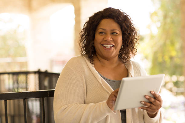 Smiling African American woman working on a tablet. stock photo