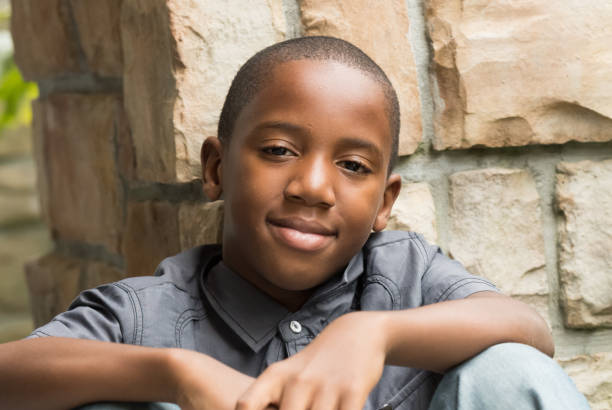 glimlachen van afro-amerikaanse jongen - alleen één tienerjongen stockfoto's en -beelden