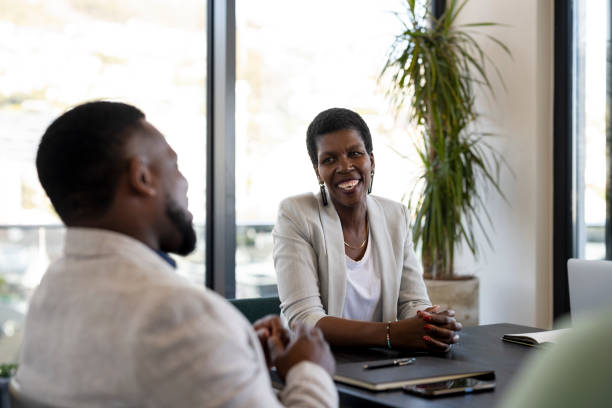 Smiling African female during meeting with male coworker stock photo