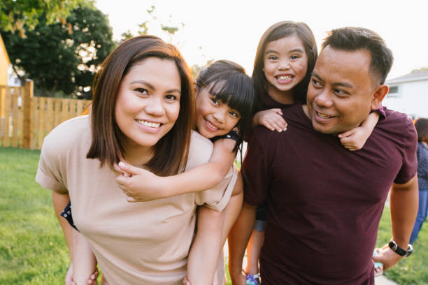 Smiling Asian family outdoor with two little kids Smiling family with two kids immigrant stock pictures, royalty-free photos & images