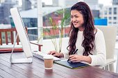 デジタル ボードとコンピューターを使ってアジアの笑顔の女性