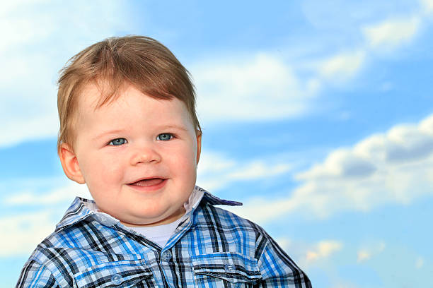 Smiling baby boy with blue eyes close up stock photo