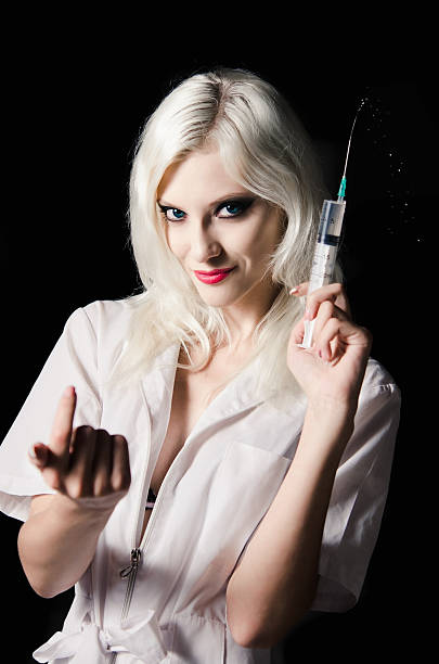 Smiling beautiful young nurse with syringe in hand stock photo