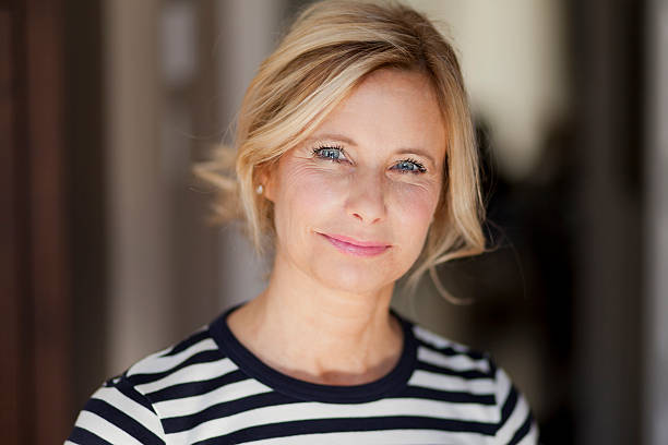 Smiling blond woman wearing a striped shirt stock photo