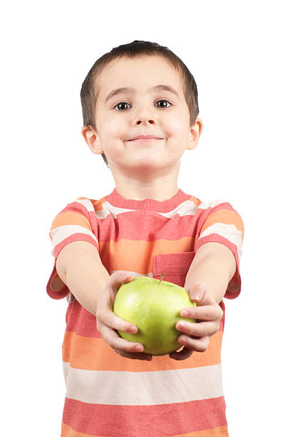 Smiling boy gives apple stock photo