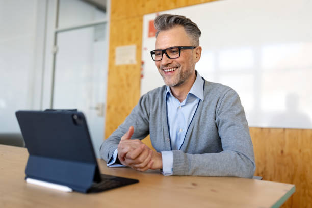 Smiling businessman having video conference over a digital tablet in office stock photo